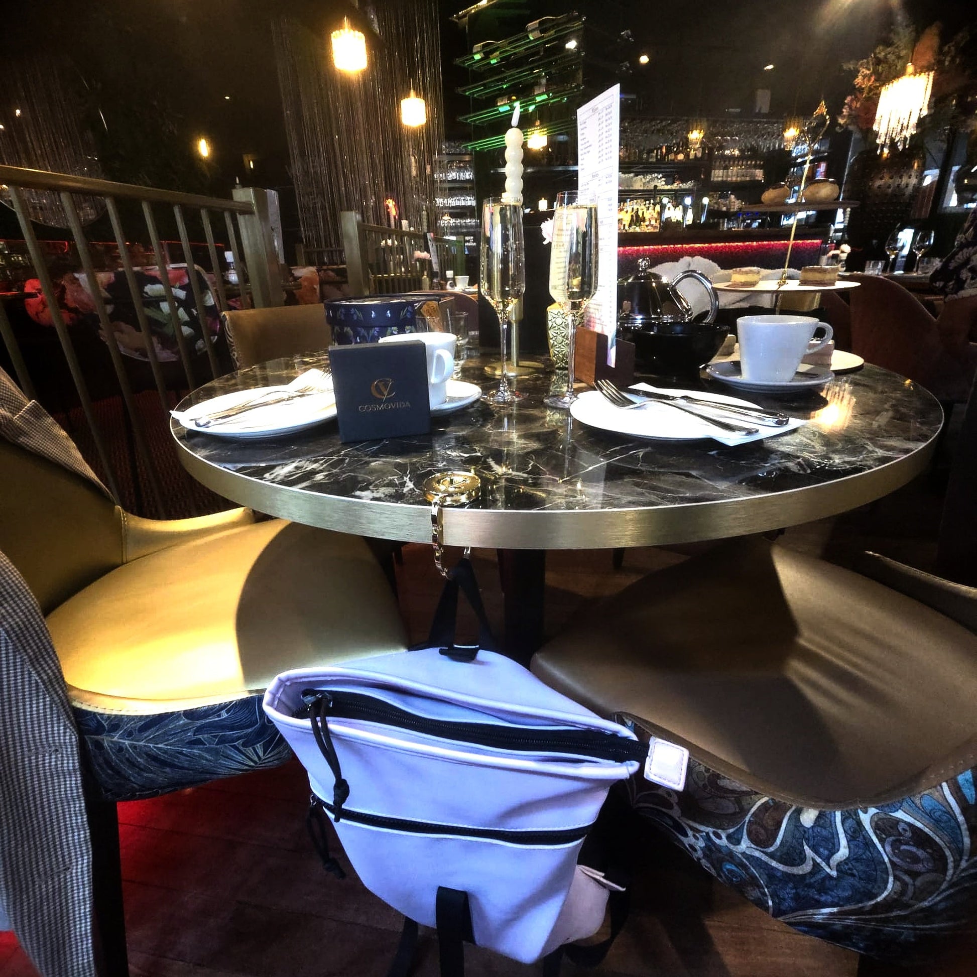 CosmoVida tassenhanger in gebruik restaurant tafel lifestyle gouden haak